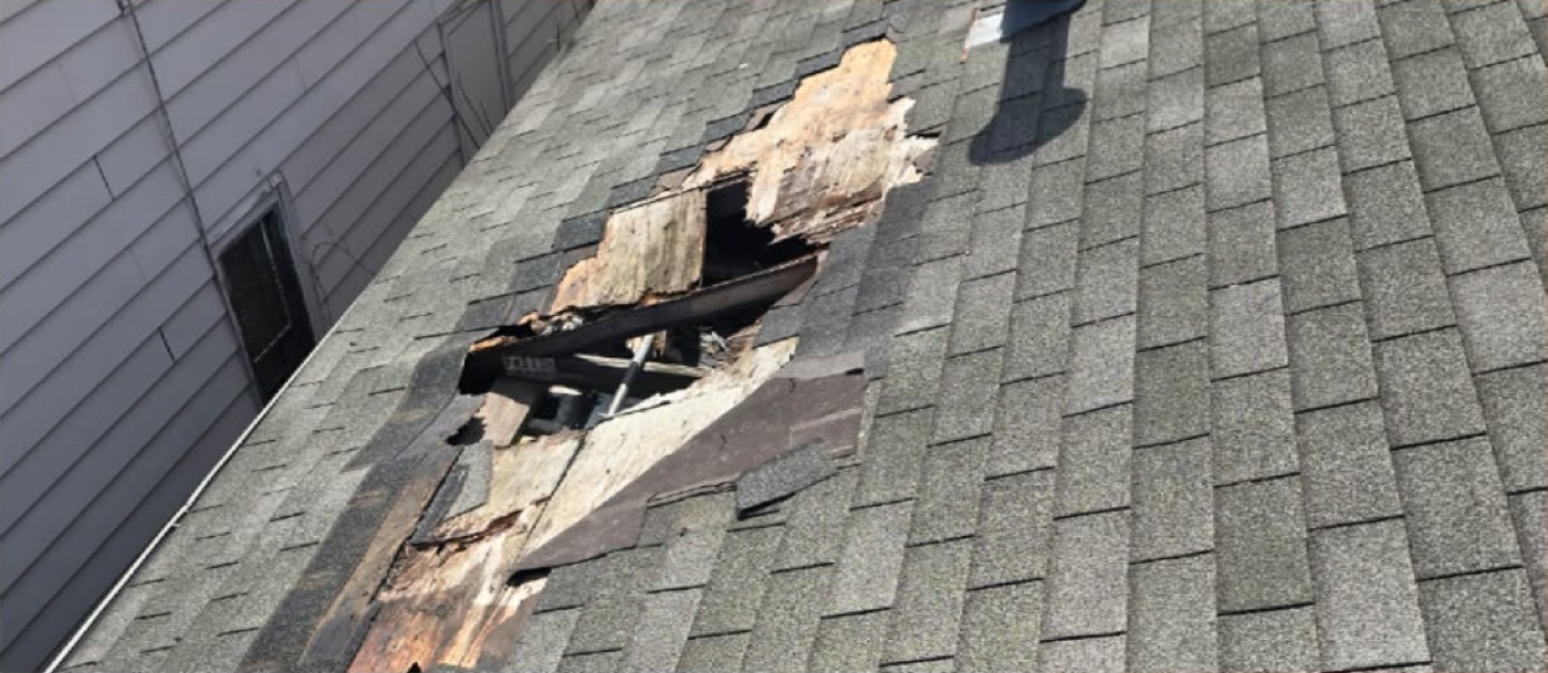 Storm-damaged roof deck before repair